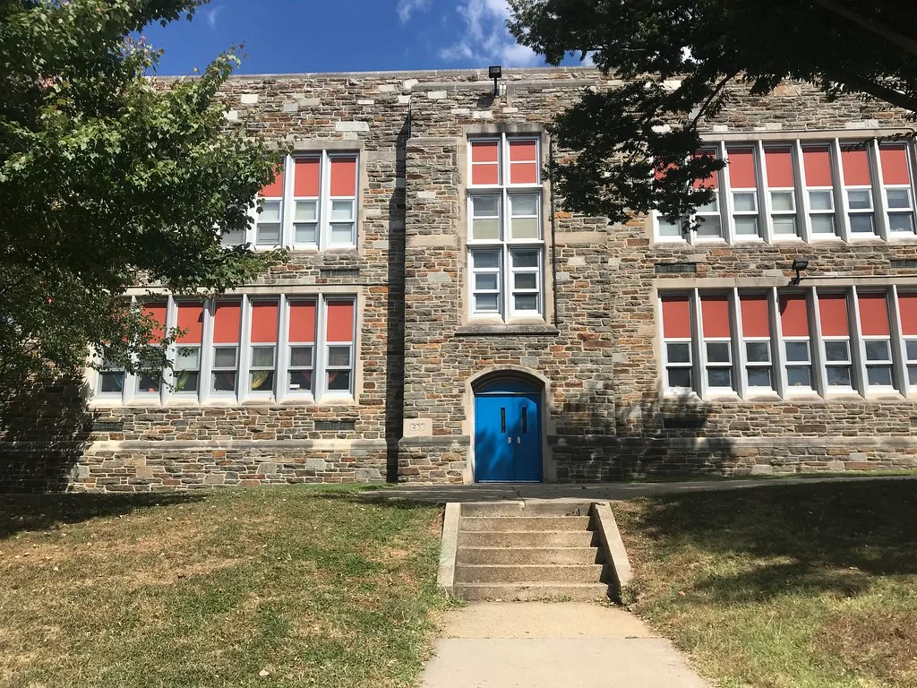 Façade en pierre de l'école Abbottston, avec une porte bleue et de hautes fenêtres.